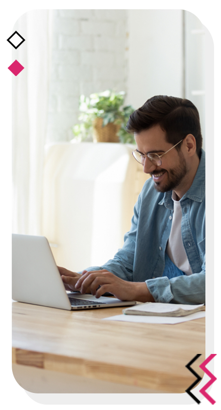 Man happily writing content on his laptop.