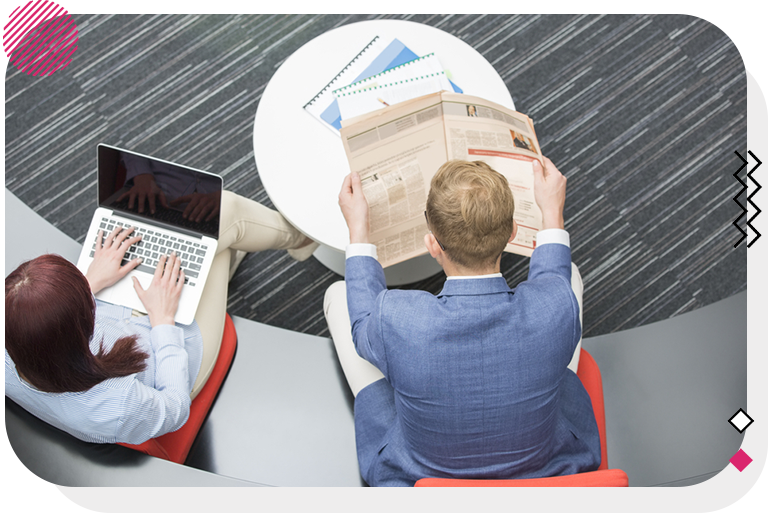 Man and woman sitting next to each other in their workplace.