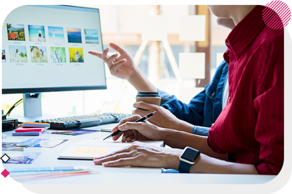 Two people pointing at a computer