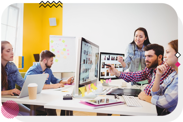 Group of people looking at a computer screen and pointing to it