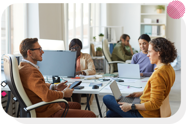 Two people in an office sitting down and talking to one another