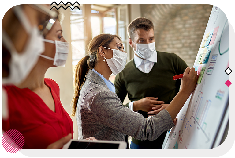 Group of people looking at a board while a woman takes notes on it