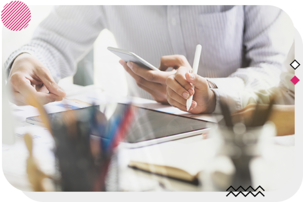 Hands of 2 people working at a desk on a tablet