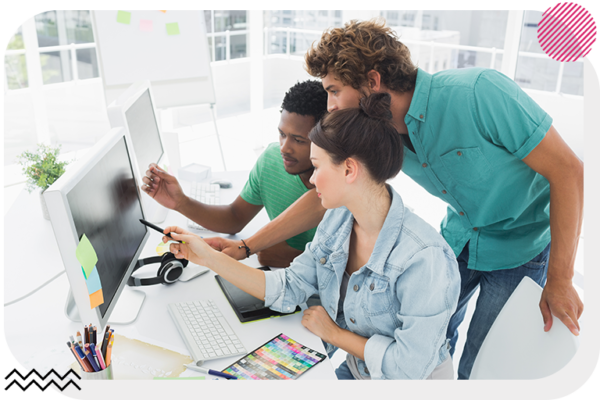 Group of people looking at a computer screen and pointing to it