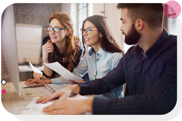 Two women and a man looking at a monitor at a desk