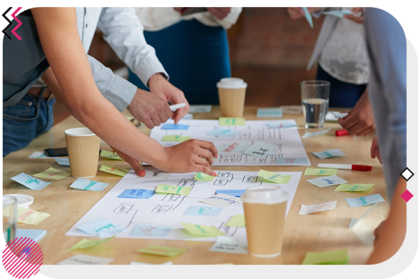 People surrounding a table with a bunch of notes on it