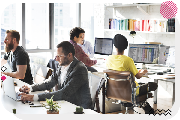 People sitting at desks back to back and working on their computer