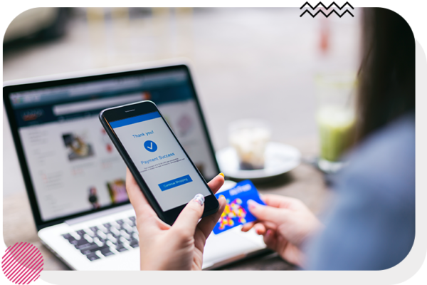 Person holding phone and credit card with a processed payment on her phone screen