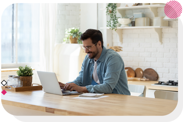 Man sitting at a table and looking at a laptop