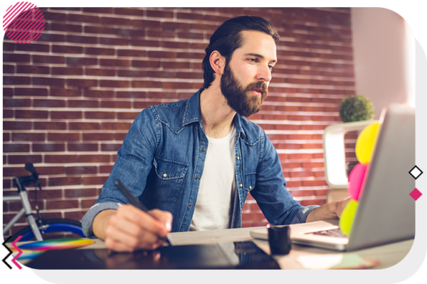 Man using drawing tablet and looking at his laptop