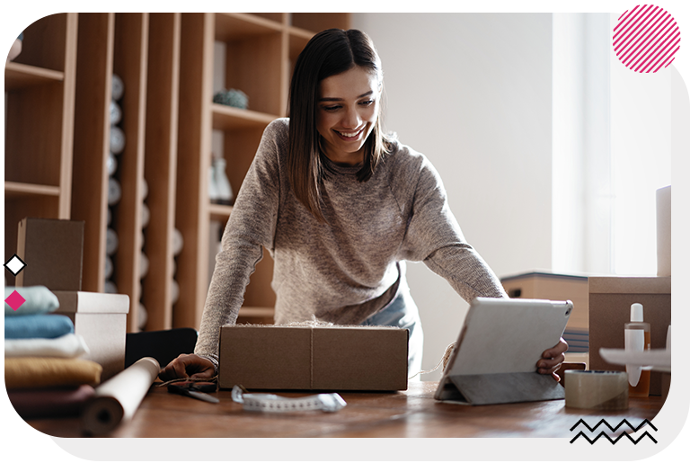 Woman using a tablet with a package in front of her