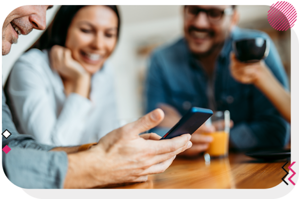 Person looking at his phone and showing it to other people beside him