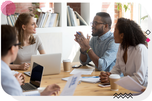 Group of people in an office talking at a desk