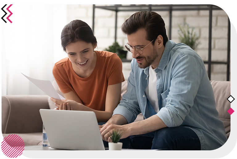 Man and woman sitting on a couch and using a laptop