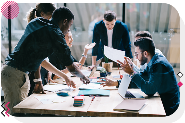 Group of people talking and looking at notes on a desk